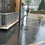 橋本駅北口のペデストリアンデッキにおいて側溝が詰まり大きな水たまりが発生しました。